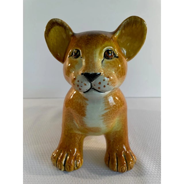 An adorable hand painted and glazed Italian ceramic Lion Cub Sculpture in lovely golden brown tones. Circa 1970s. "Made in...