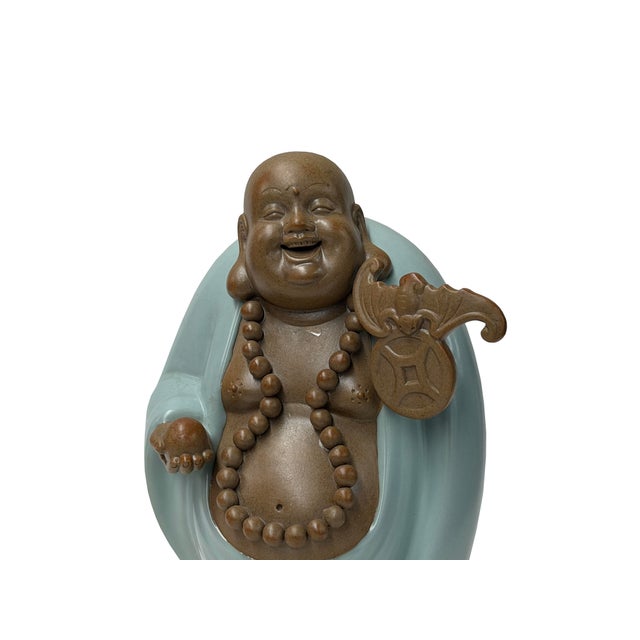 This charming glazed ceramic figurine depicts a joyful, bald Laughing Buddha with a gleaming, smooth brown finish and a...