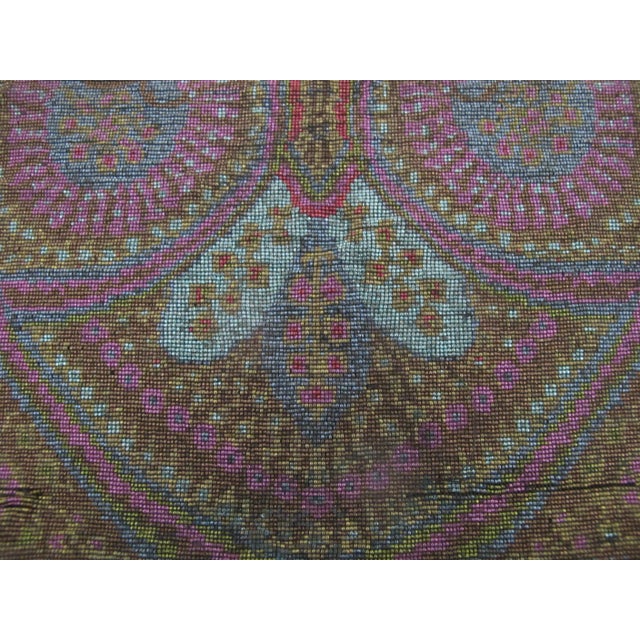 Victorian era micro-beaded pouch featuring an intricate colorful paisley and floral pattern in muted shades of pink, blue,...