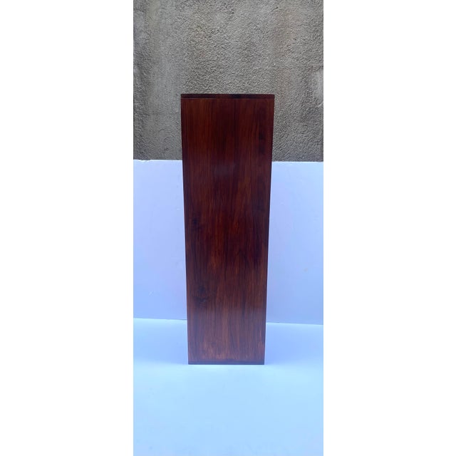 A rich brown stained oak wood pedestal column stand, Midcentury Modern Design period, circa mid‑20th century. The piece...