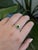 A demantoid garnet glows in a vivid grass green at the centre of this solid 14K white gold ring, encircled by twenty-six...
