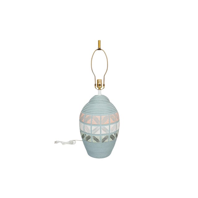 A postmodern ceramic table lamp circa 1960. Decorated with bands of incised squares in peach, white and green, against a...