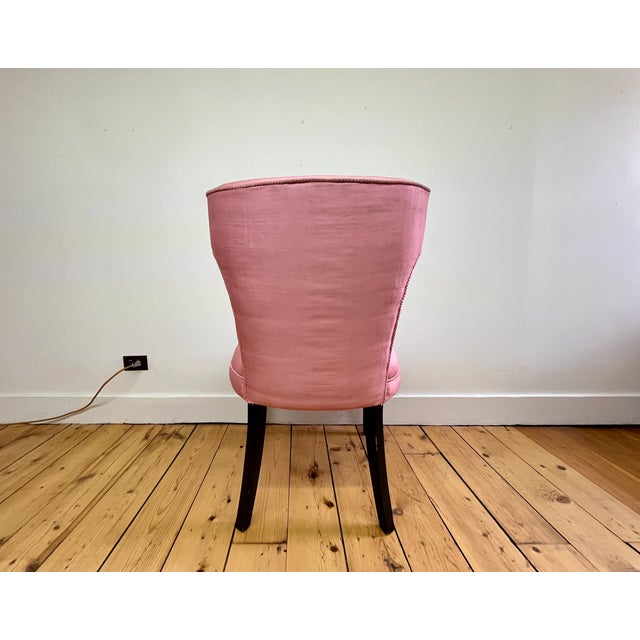 Pair of vintage dining chairs featuring an elegant sculptural silhouette with softly curved backs and tailored pink silk...