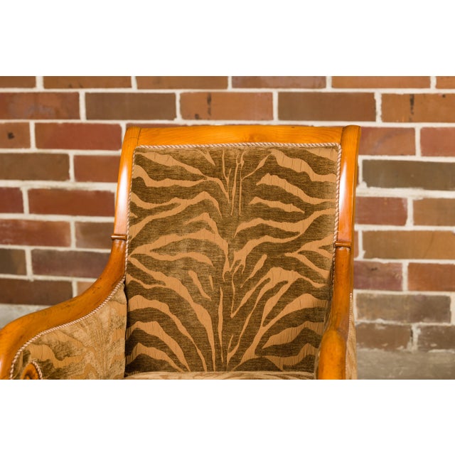 A pair of French Louis Philippe style walnut bergère chairs from the 19th century with scrolling arms, carved front legs...