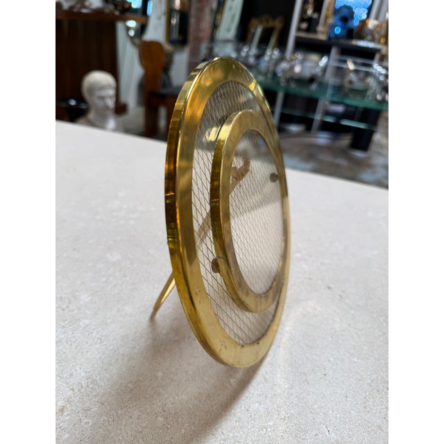 Elegant vintage tabletop photo frame featuring a circular design with a brass outer rim and decorative mesh overlay set...