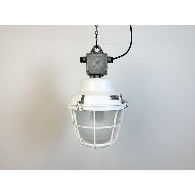 Industrial light made by Elektrosvit in Czech republic during the 1990s. It features a white iron top with cast aluminium...