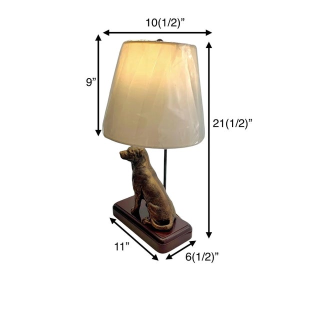 Charming golden retriever sculpture lamp with golden finish on wooden base. Dog lovers will adore its character....