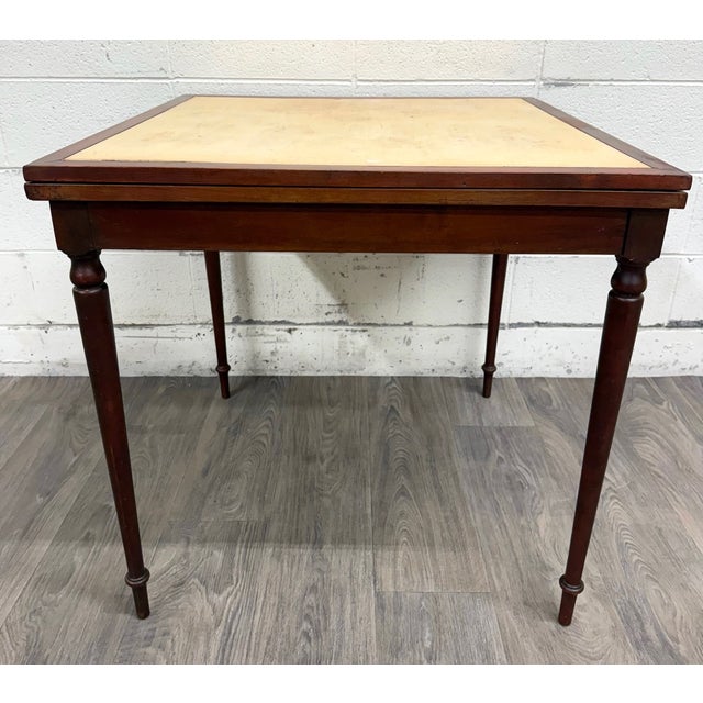 This is a vintage mahogany folding card table or game table featuring a warm mahogany finish, turned legs, and original...