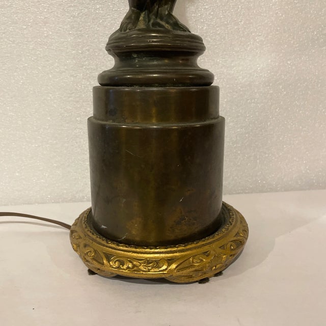 Fine turn-of-the-century French bronze electric lamp in the form of a cherub on a pedestal holding a Greek key scroll...