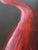 A striking abstract composition defined by a single flowing crimson form moving across a deep black background. Executed...