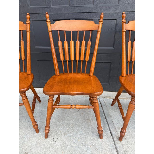 Beautiful set of four dining chairs with classic spindle-back design, turned legs, ano sturdy solid-wood construction....