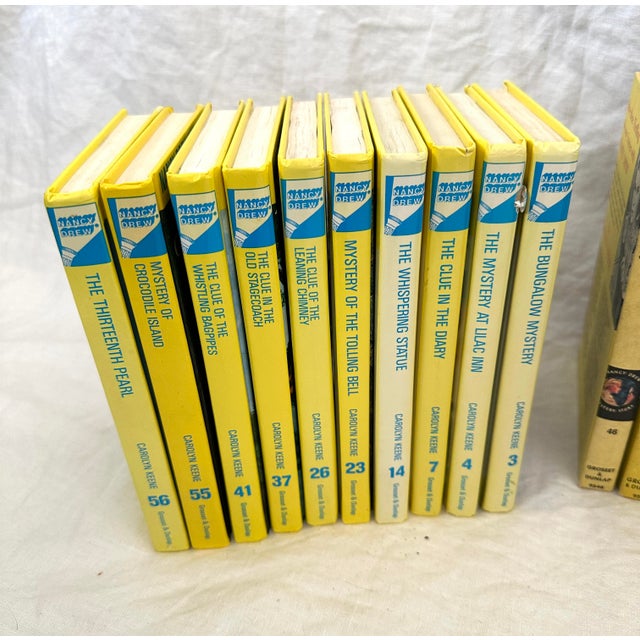Set of 23 vintage yellow books from the Nancy Drew series. New York: Grosset & Dunlap, 1950's-1970's. Includes select...