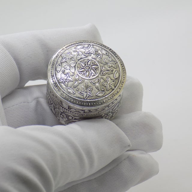 This vintage silver decorative object depicts a round pill snuff trinket box, crafted as a vanity table centerpiece, desk...