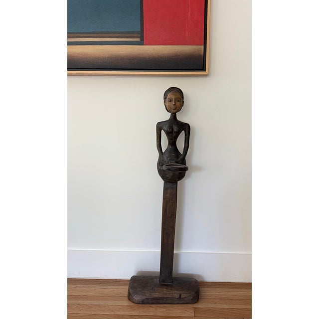 Vintage hand carved wood sculpture of an elongated woman figure, possibly of African origin. Lighter facial features and a...