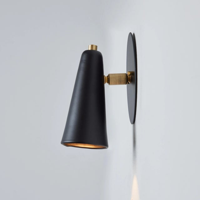 Pair of 'Lupita' sconces in black and brass by Alvaro Benitez. Hand-fabricated by Los Angeles based designer and lighting...