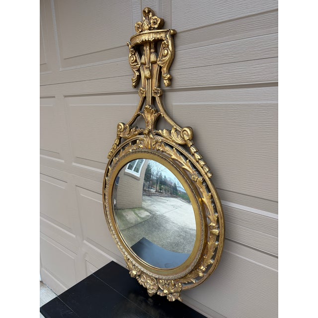 A beautifully proportioned mid-20th century convex wall mirror in the Robert Adam style, featuring a classic giltwood...