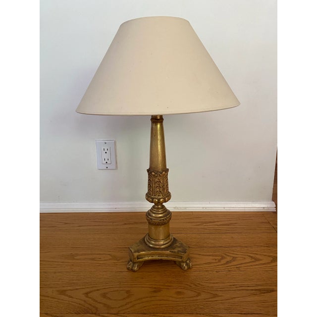 Traditional revival neoclassical style lamp, exemplary by the paws as feet. This is finished in genuine 22k gold leaf over...