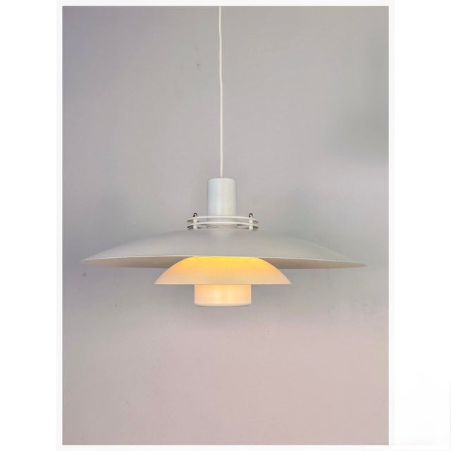 A minimalist Danish pendant lamp produced by Form-Light in the 1980s. The design features two gently curved white...