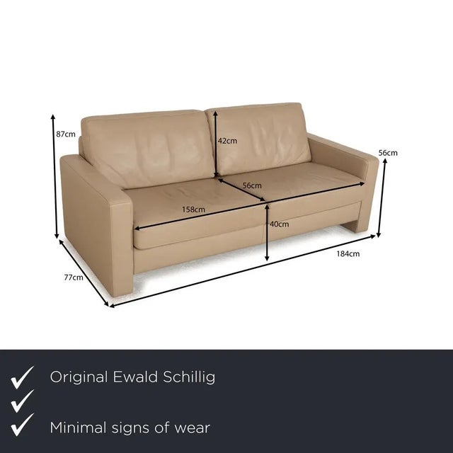 The sofa by Ewald Schillig is covered in beige leather and stands on floor-to-ceiling side panels. The three-seater is...