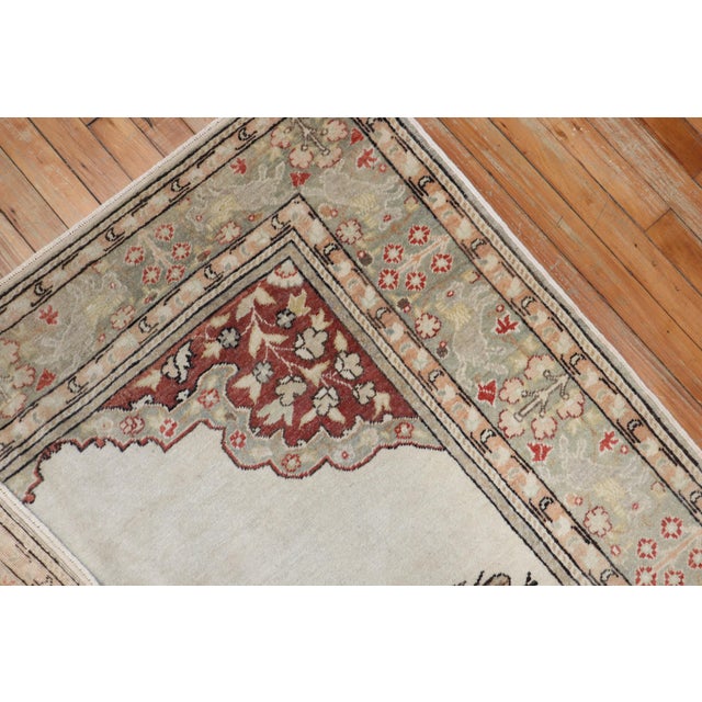 mid 20th century one of a kind Turkish Rug depicting a large lion and small bird on a white field and silver floral...