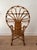 This vintage bent rattan peacock armchair features a sculptural fan-shaped back with beautifully curved cane detailing and...