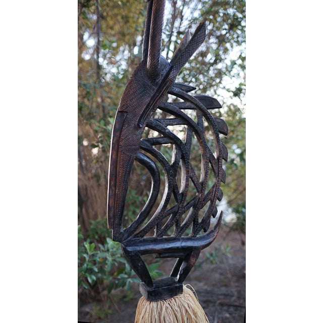 Monumental Chi Wara Style Sculptural Floor Lamp with Raffia Skirt Few lighting pieces possess the commanding presence of...