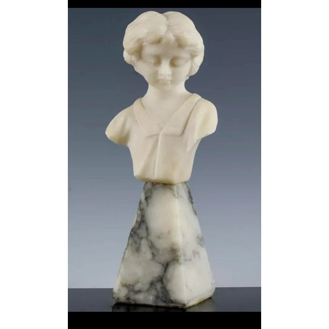 A charming hand-carved alabaster bust of a child circa 1920. Sweet features and attached to it's original marble base....