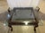 An elegant vintage Chippendale-style mahogany coffee table featuring a distinctive square silhouette. The table boasts an...