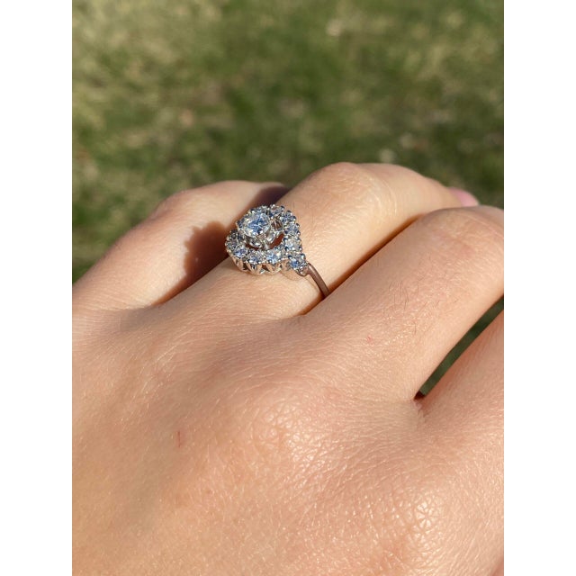 The Hol: Hollywood Glam Era Natural Diamond Engagement Ring in White Gold. This captivating ring centers on a brilliant...