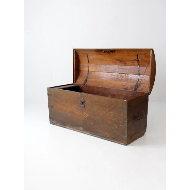 A Norwegian antique wood trunk. This grand, dome top chest features iron hardware and lock. It opens to a generous storage...