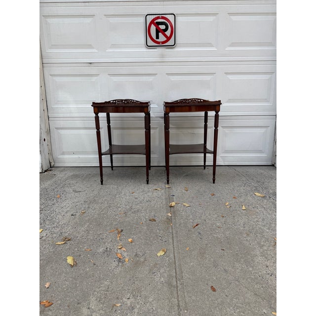 We have an absolutely stunning pair of vintage Federal Revival mahogany side tables for sale. They feature elegant...