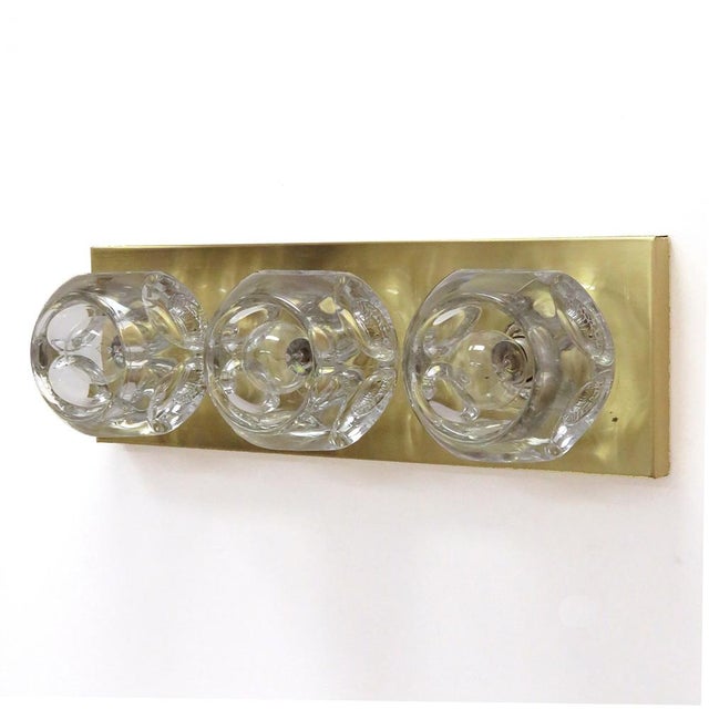 Stunning cubic wall light by Peill & Putzler, Germany, with three large faceted, solid glass spheres with artful bubble...