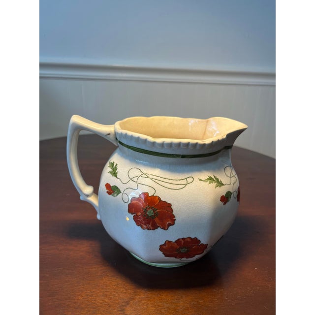 Antique Crown Pottery pitcher . Poppy design in red with green leaves . Produced in 1920