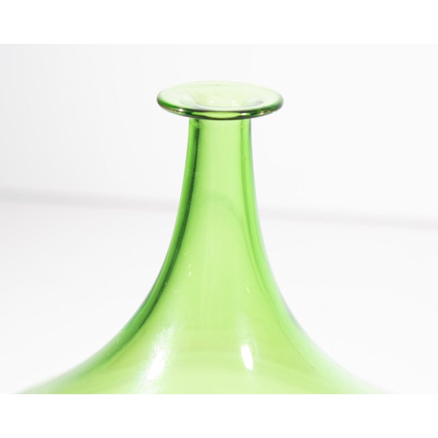 A Murano art glass vase. Made in Italy, this vase has a slender neck with green top and wide purple lower half. The...
