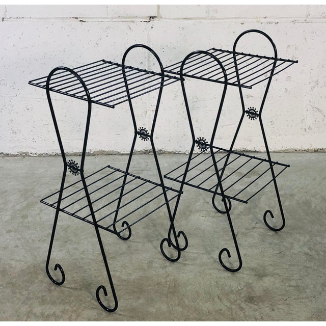 1960s black metal side tables with two shelves and a side floral decoration. Newly refinished and in excellent condition.