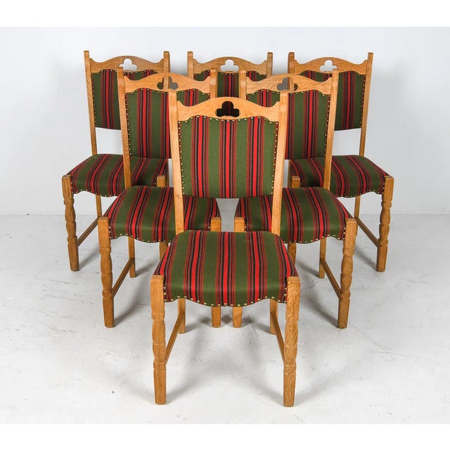Set of six oak dining chairs with carved trefoil cut-out backs and turned legs, each retaining its original wool...