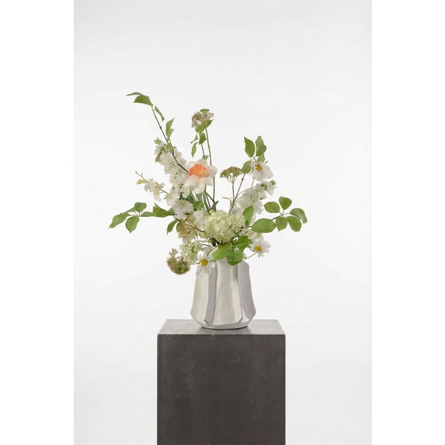 A fresh, tonal composition of cream cosmos, white lilac, and soft green snowball with subtle yellow accents. The palette...