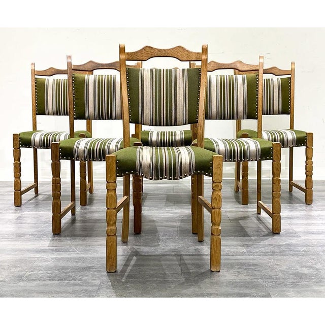 A set of 6 Danish mid-century modern dining chairs in carved/figured oak with striped upholstery and brass tacking...
