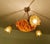 Italian art deco pendant light featuring an honey marroon agate alabaster bowl with bronze satyr mount paired with three...