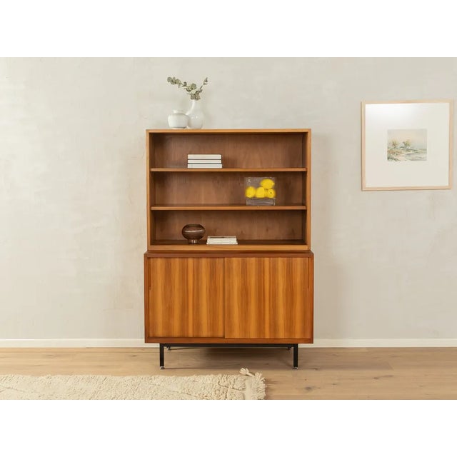 Puristic two-piece chest of drawers from the 1950s. High-quality body in walnut veneer with two sliding doors, three...