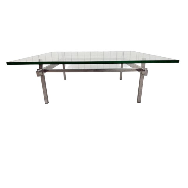 This stylish Mid-Century Modern coffee table features a sleek architectural chrome base paired with a large clear glass...