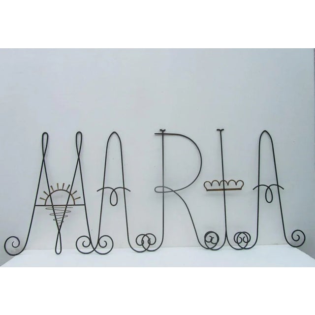 This iron letter sign reading 'maria' was part of the interior of a church in holland during the early 1900s. The piece is...