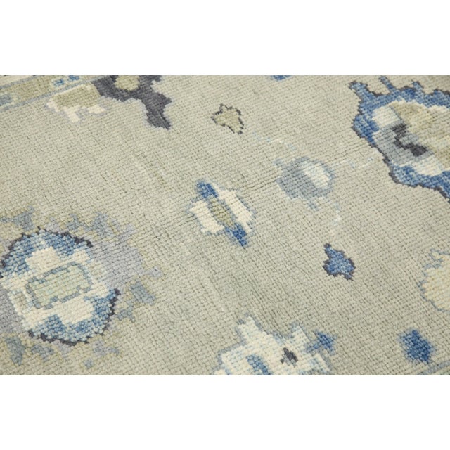 This modern Turkish Oushak rug is a stunning piece of art that has been handwoven using traditional techniques by skilled...