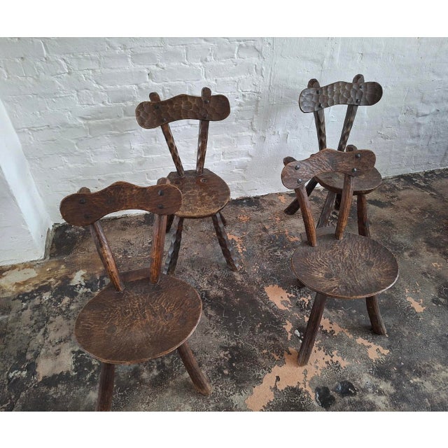 Set of 4 hand-crafted Brutalist elm or oak chairs after Alexandre Noll, France 1950s. 2 of the chairs are tripod chairs, 2...