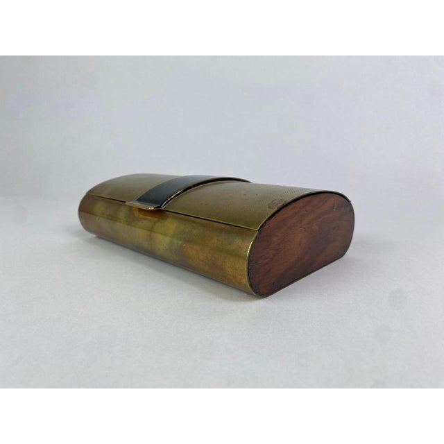 Brass and wooden cigarette box, designed by Carl Auböck, shows a beautiful guilloche top surface. The brass shows fine...