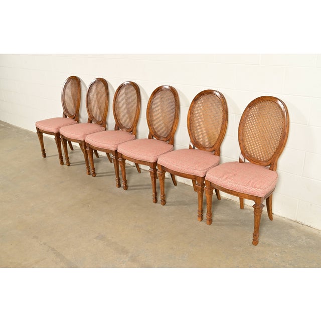 A gorgeous set of six French Regency Louis XVI style dining chairs By Drexel USA, Circa 1960s Carved walnut frames, with...