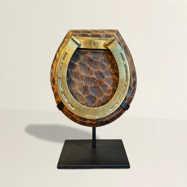 An early 20th-century English desk clip—brass horseshoe, chip-carved wood—once lived a dutiful life pinning down...