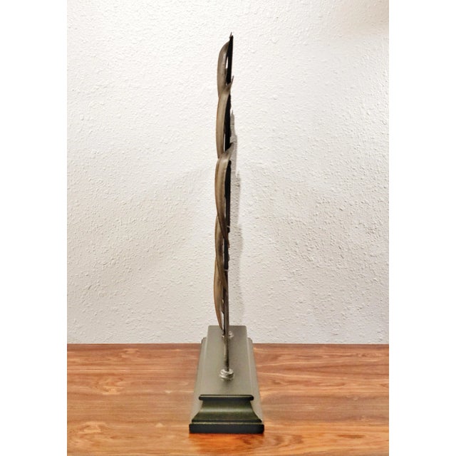 An intriguing, hand-made, metal tabletop sculpture on a wooden stand from VILLA COLLECTION DENMARK, a retailer/distributor...