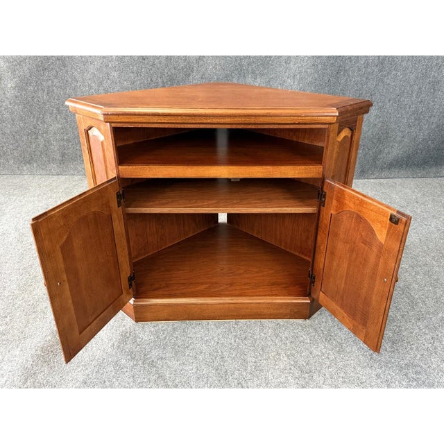 This cherry corner television stand features a space-saving triangular design ideal for fitting snugly into a room corner....