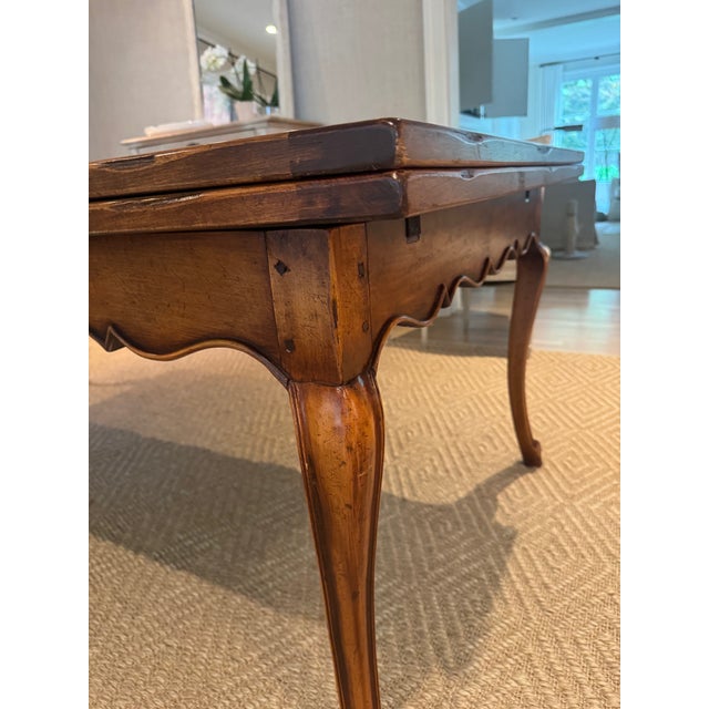 French Régence Provincial-style walnut draw-leaf table crafted with a beautifully hand-hewn top and breadboard ends,...